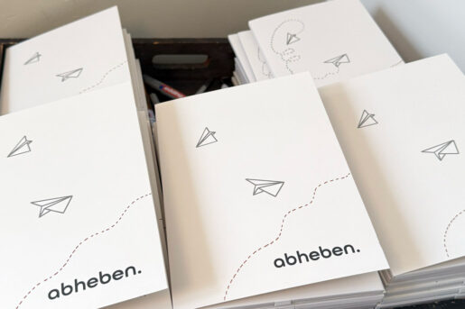 Gestapelte Direct-Mailing-Soundkarten für Ralf Andres mit Papierflieger-Illustrationen und dem Schriftzug ‚abheben‘.